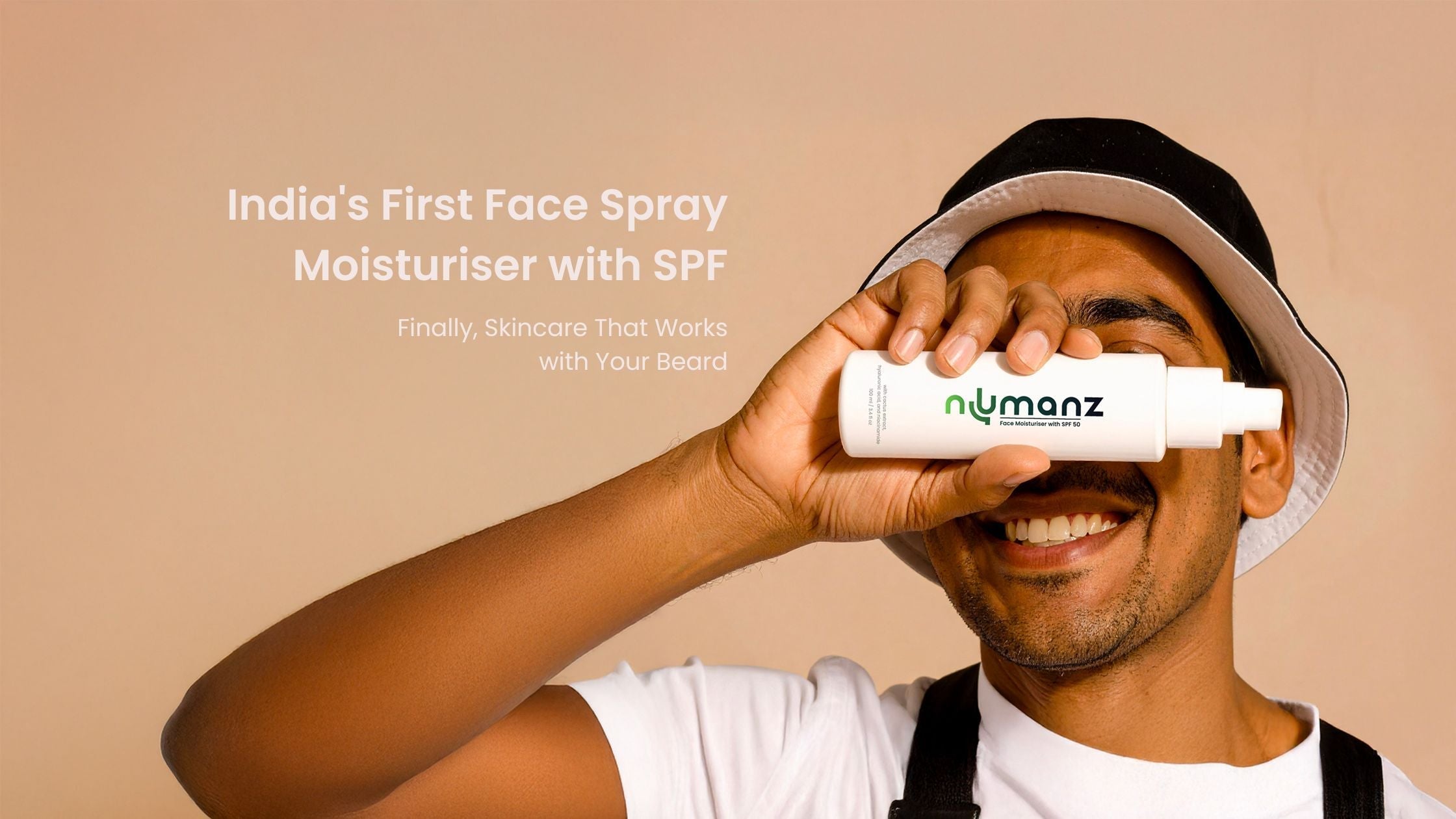 Indian man smiling while holding Numanz face spray moisturiser with SPF for men across his face. Banner text reads ‘India’s First Face Spray Moisturiser with SPF – Finally, Skincare That Works with Your Beard.’ Premium men’s skincare product image.